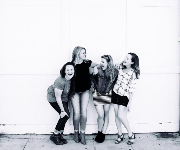 Foto en blanco y negro donde amigas sonríen divertidas riendo es la mejor terapia de mujeres